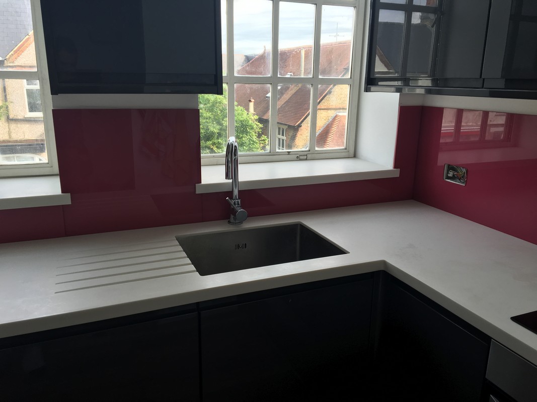 Deep plum coloured glass splashback in modern Leyton kitchen